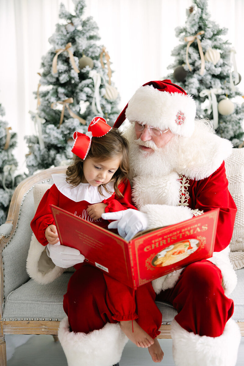 a girl reading a book with Santa