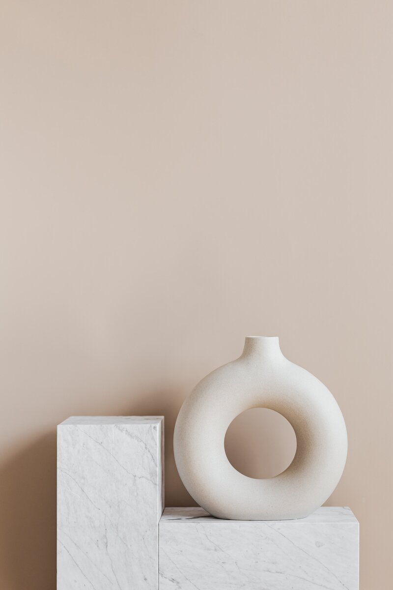 white vase against a brown background