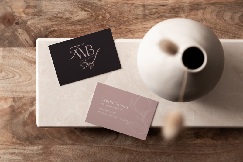 Business cards sit on wooden table next to bud vase, designed by Knoxville brand agency Liberty Type
