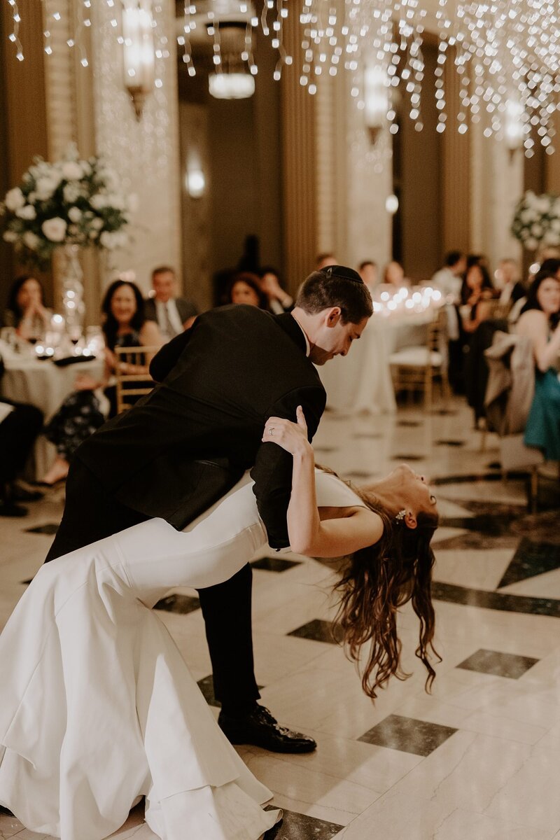 Groom dipping bride while dancing