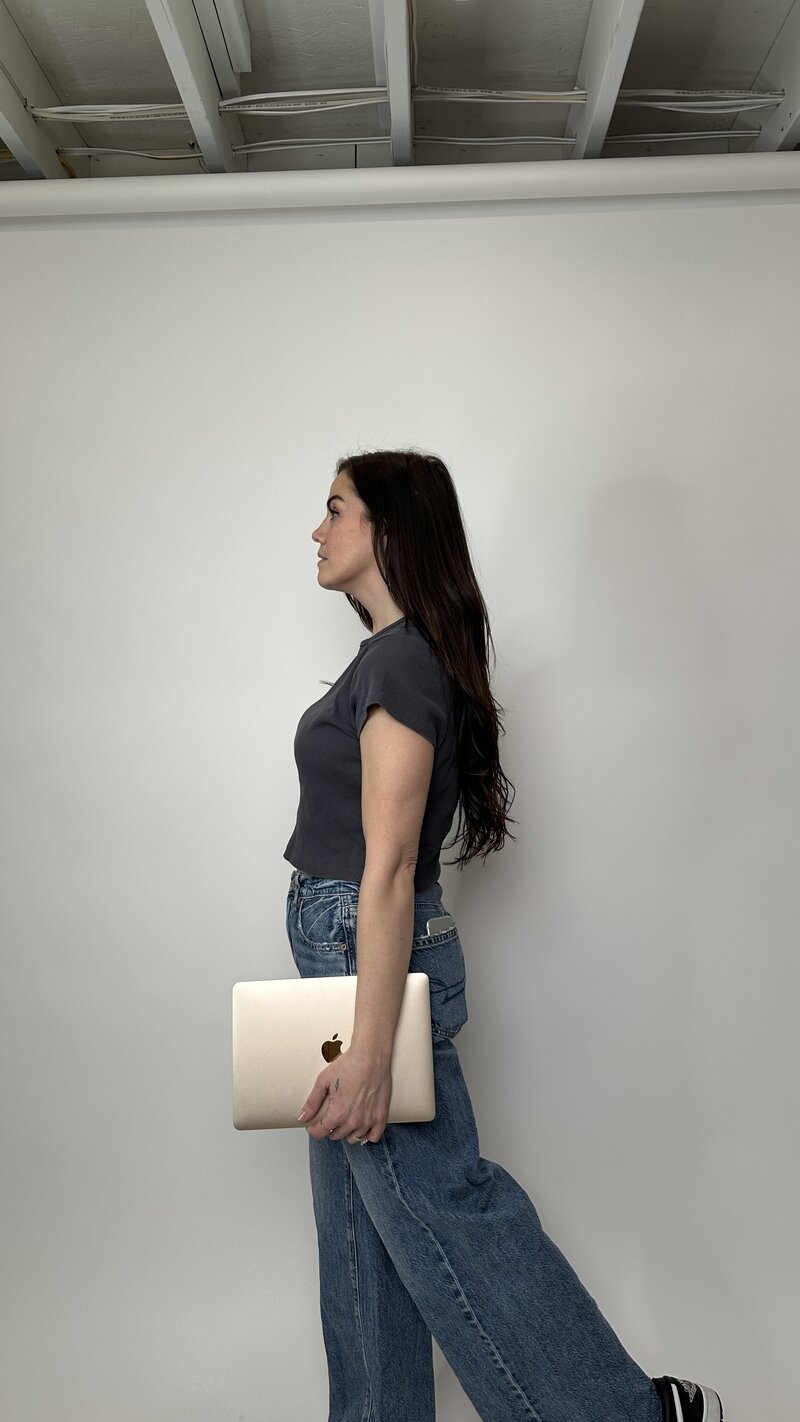 Girl standing holding her Apple Macbook