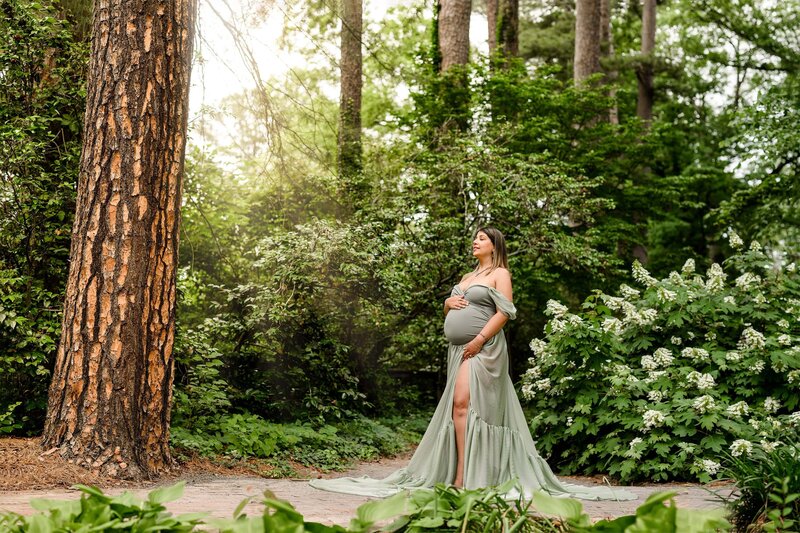 charlotte mom standing in a garden in a green dress