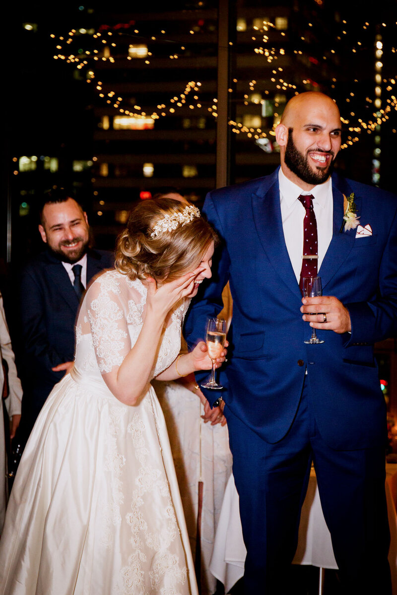 Bride gets emotional while holding champagne at wedding reception