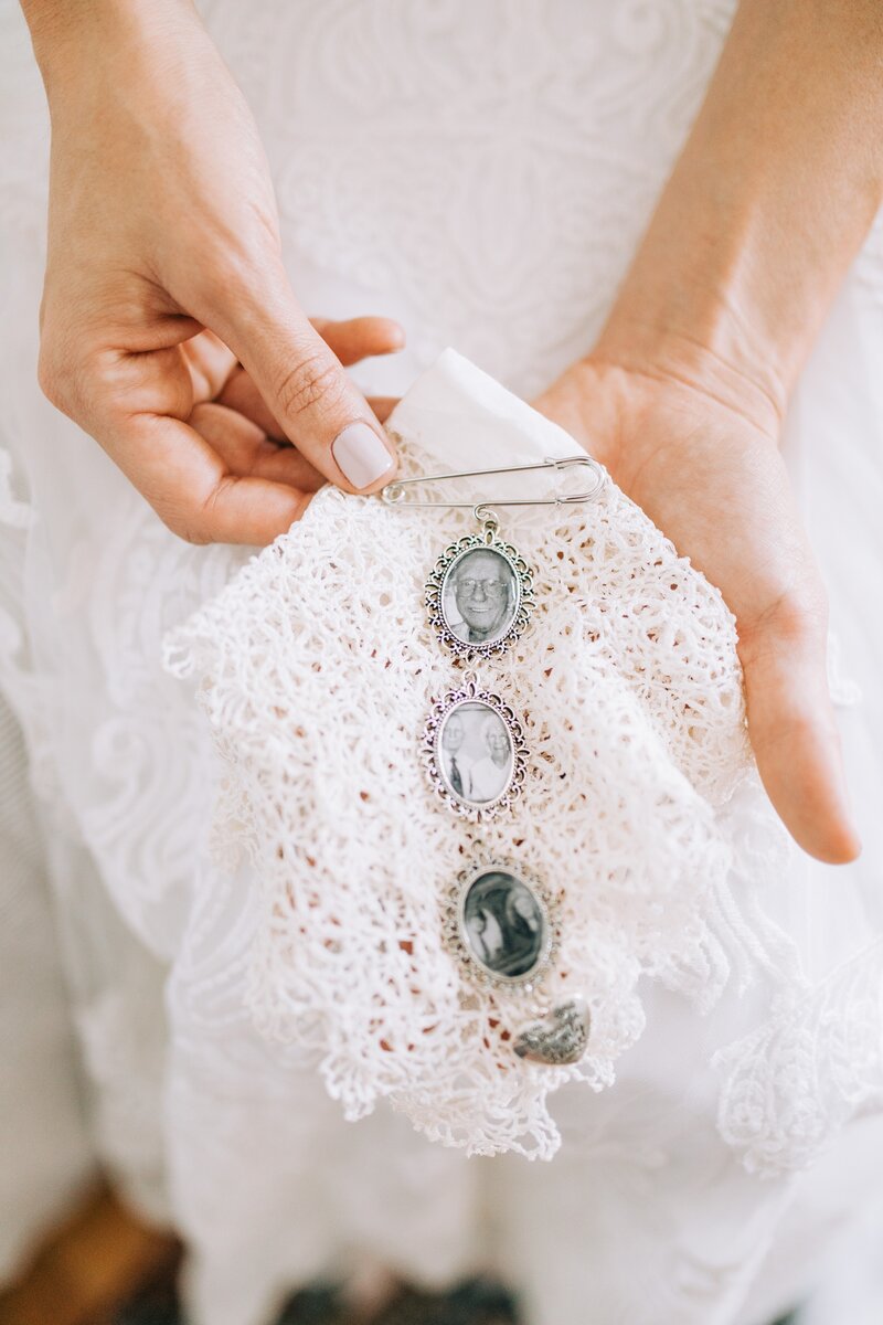 bride holds heirloom handkerchief and pendants to honor loved ones