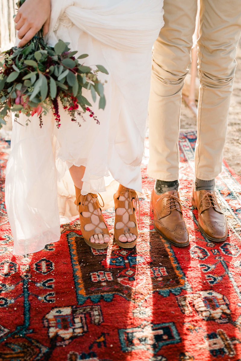 elopement details of the brides shoes. bouquet, and dreamy boho rug