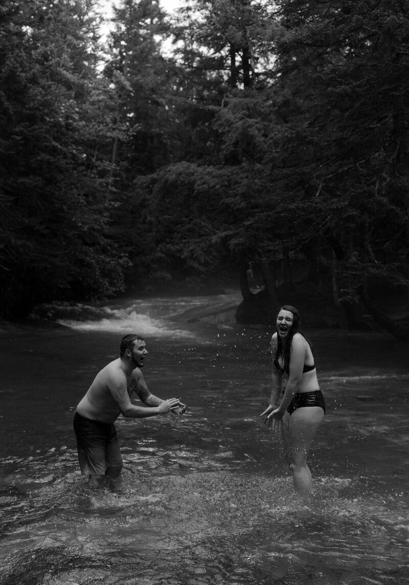 a couple playing in the creek together for their documentary engagement photos