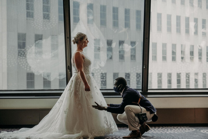 man fixing brides gown