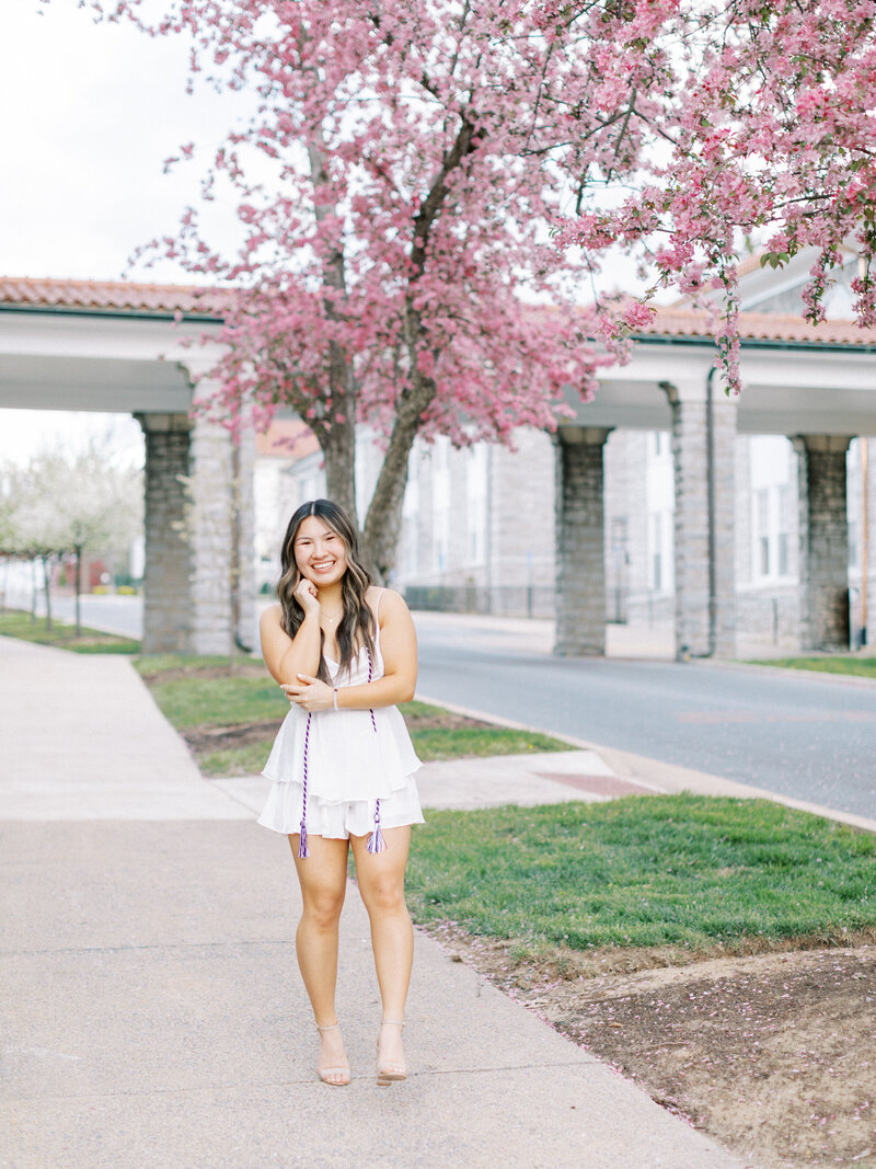 A spring senior session by cherry blossoms in Harrisonburg, VA at James Madison University.
