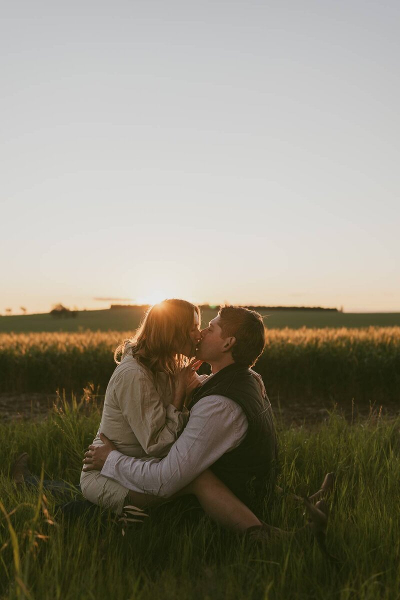 Romantic couples photoshoot at sunset with a couple kissing in a field in Central West NSW.