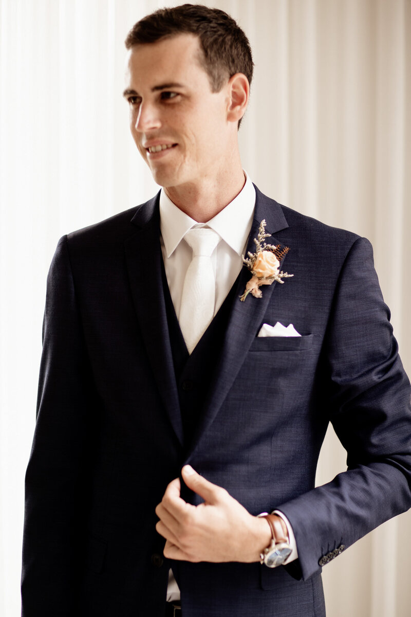 Groom wearing his suit and boutonniere