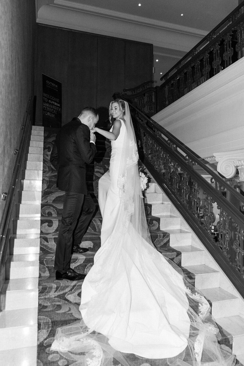 black and white photo of bride and groom on stairs at the omni king edward  hotel
