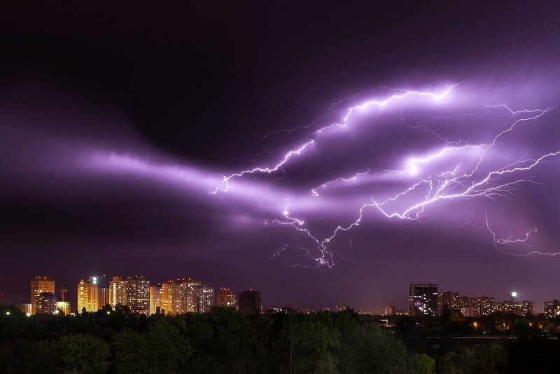 lightning bolts shooting across the sky above a city