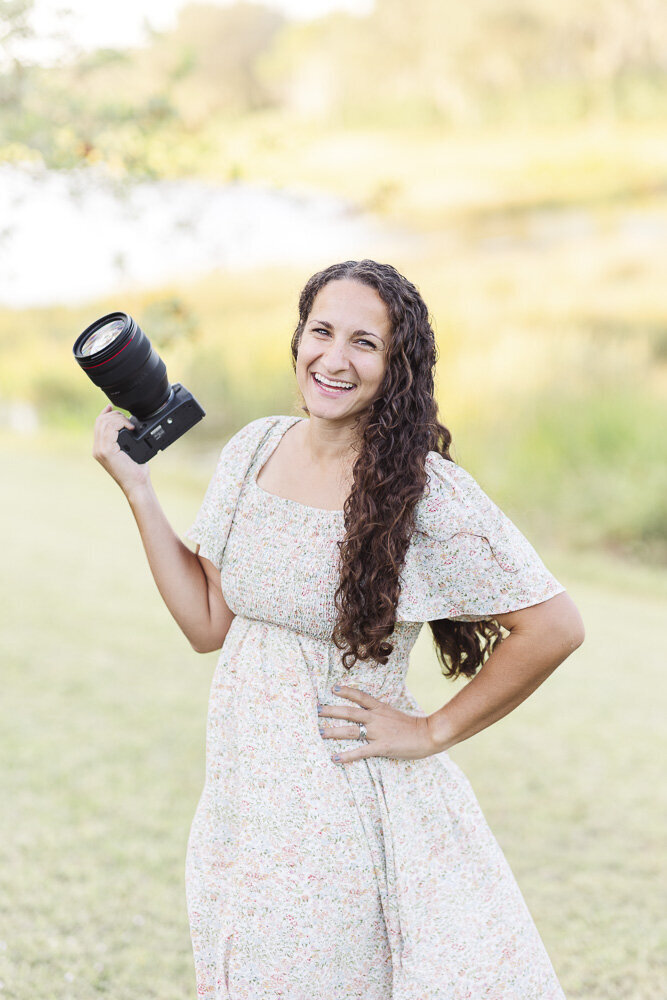 Deanna smiling while holding a camera