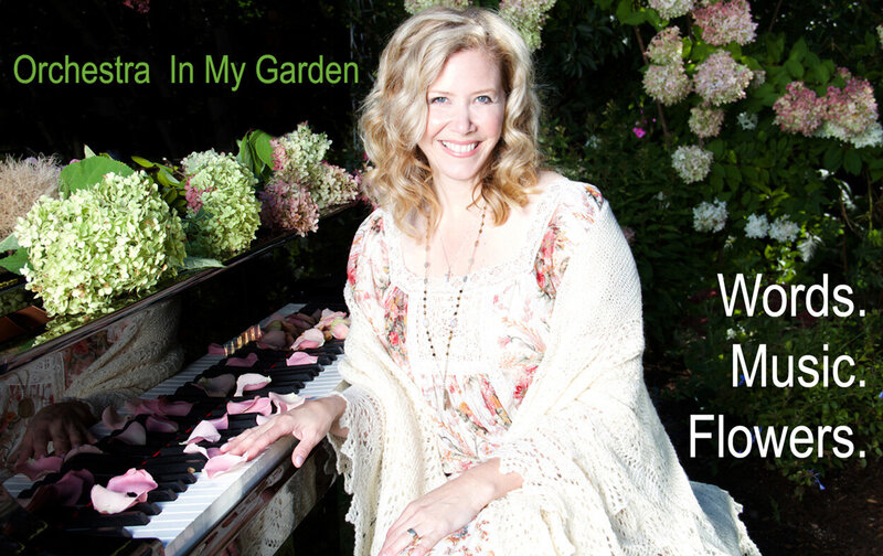 Branding promotional photo Author Linda Brooks sitting at grand piano covered in flowers and flower petals one hand on keys