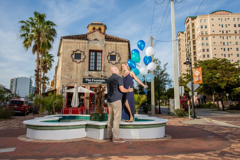 couple posing near a fountain holding balloons,  downtown Sarasota
