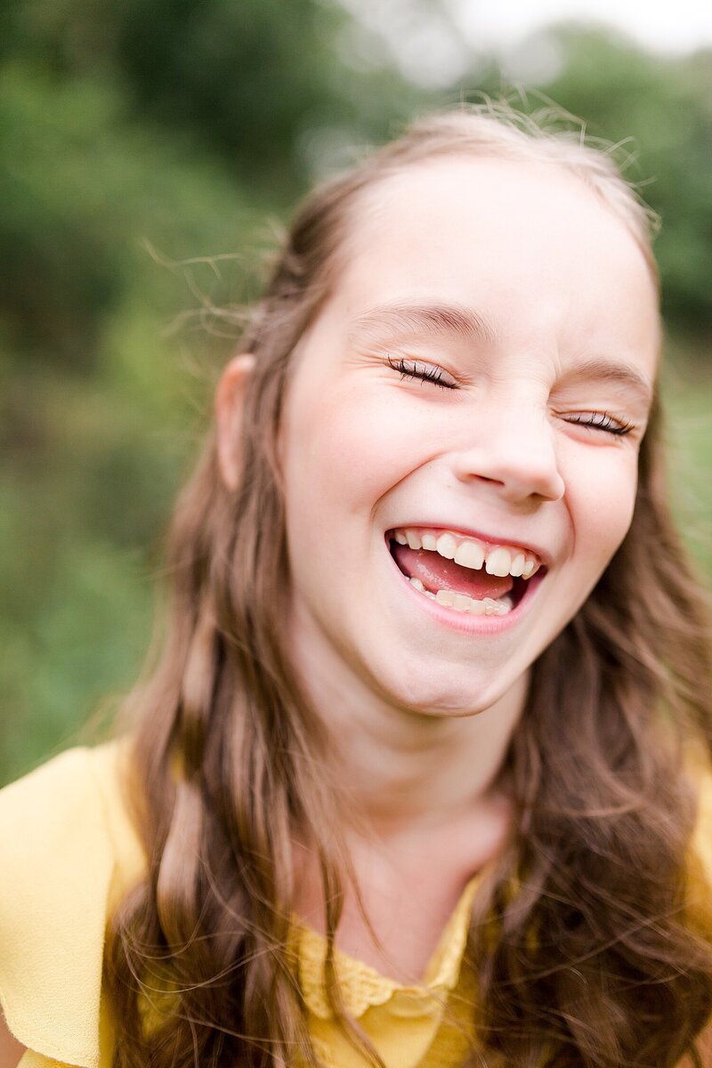 A girl laughing during a family photo session in Georgetown KY.