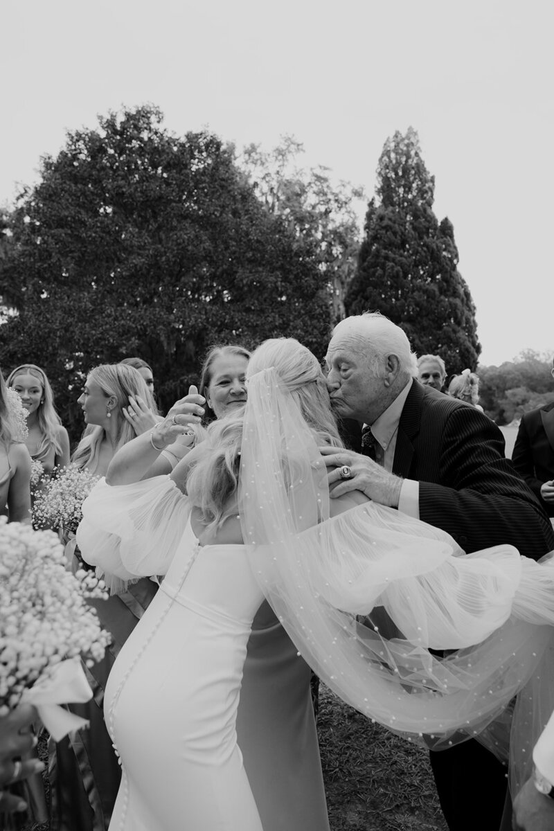 Bride is greeting family and friends to her wedding captured in black and white by Charleston Wedding Photographers