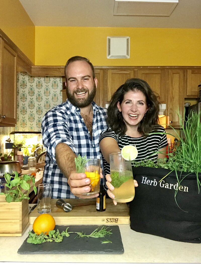 Coupe smiles while holding cocktails with herbs from Gardenuity herb garden