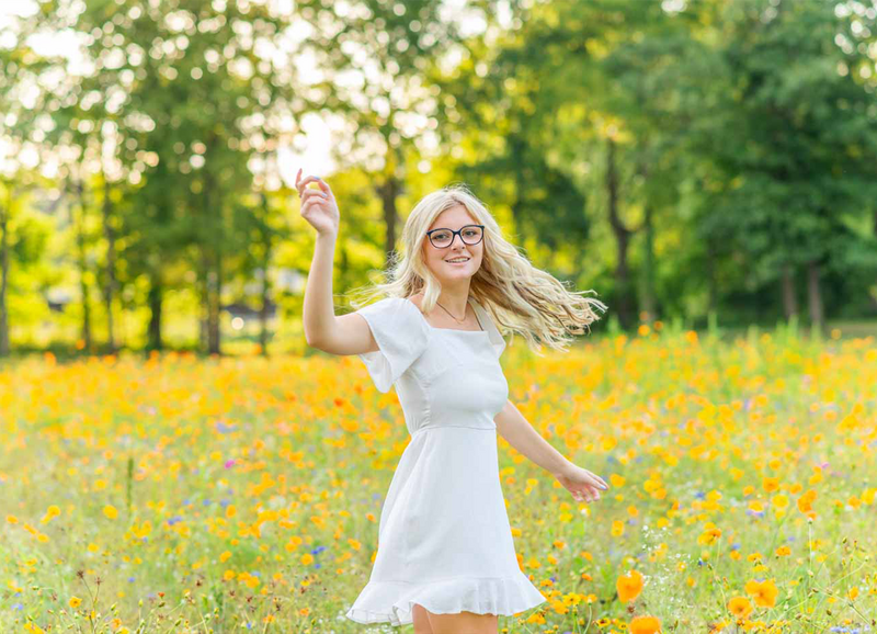 high school senior girl twirling in wildfllower field located in ionia michigan