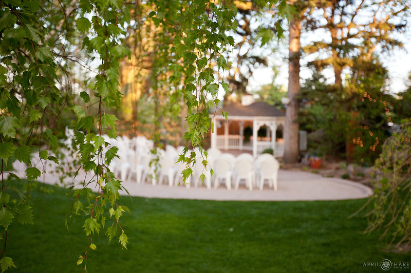 Trees surround the outdoor  ceremony space on the front lawn with gazebo at Tapestry House