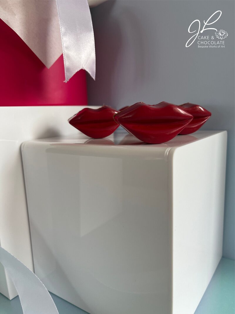 Red lip luxury chocolate bonbons with gift box and bow in background
