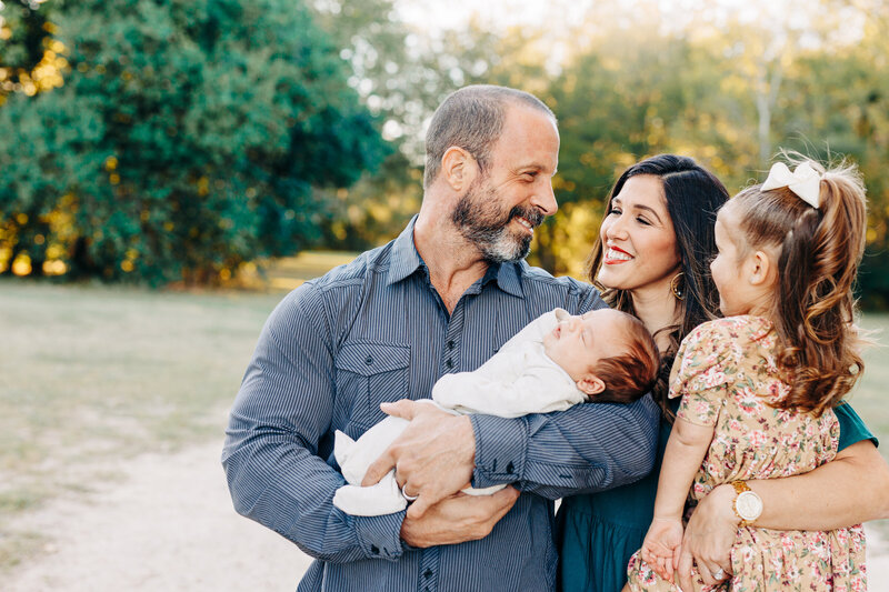 family with their 2 children in their arms during an outdoor family session