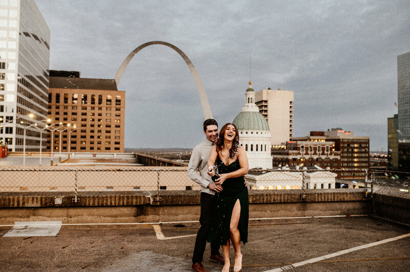 Engagement session parking garage St Louis Arch in background champagne pop on the roof Missouri Wedding Photographer