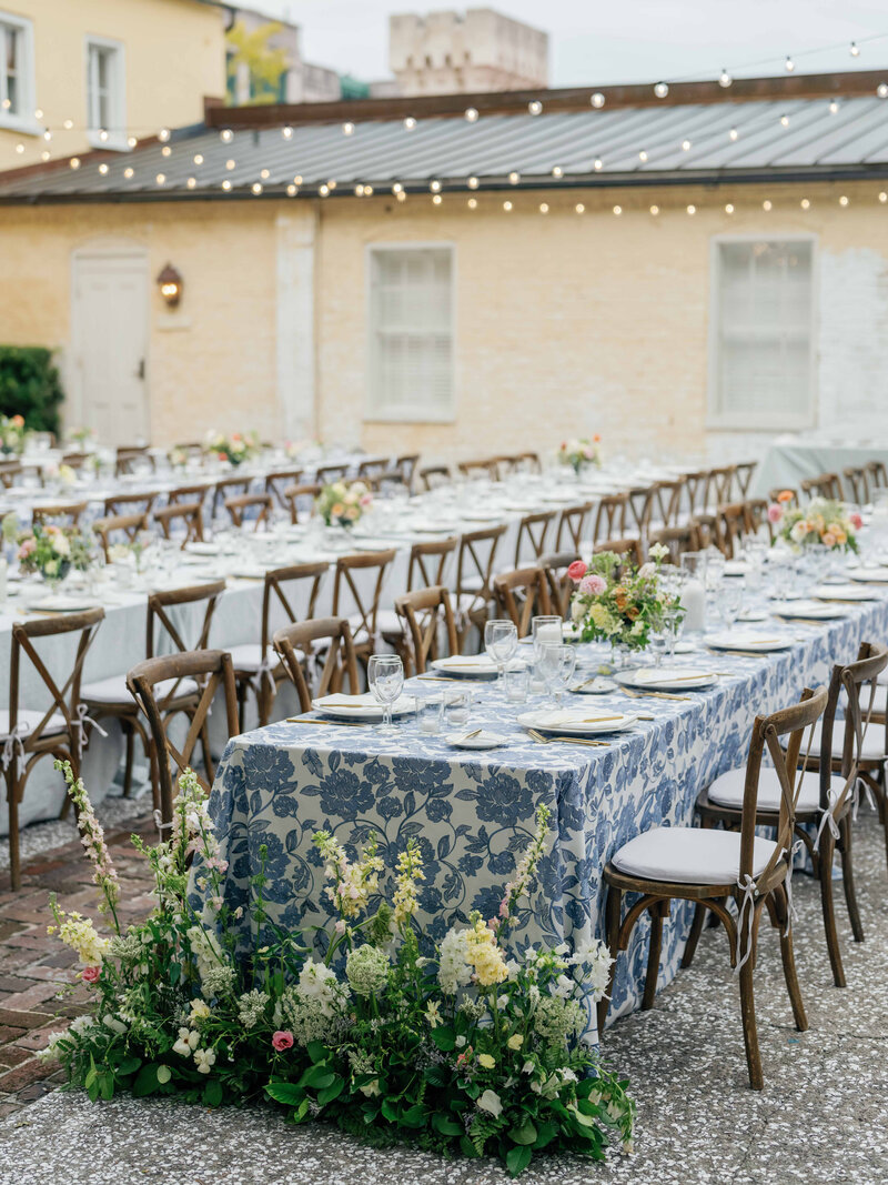 Outdoor wedding reception table design, long tables with blue floral tableclothes
