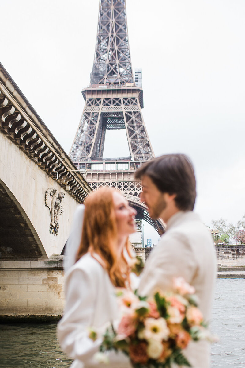 couple staring at each other in front of eiffel tower