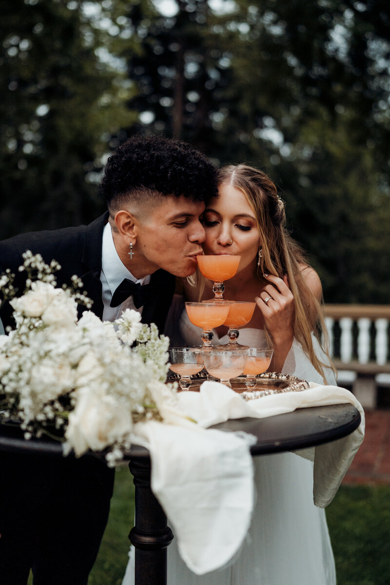 couple sip cocktail together at wedding elopement
