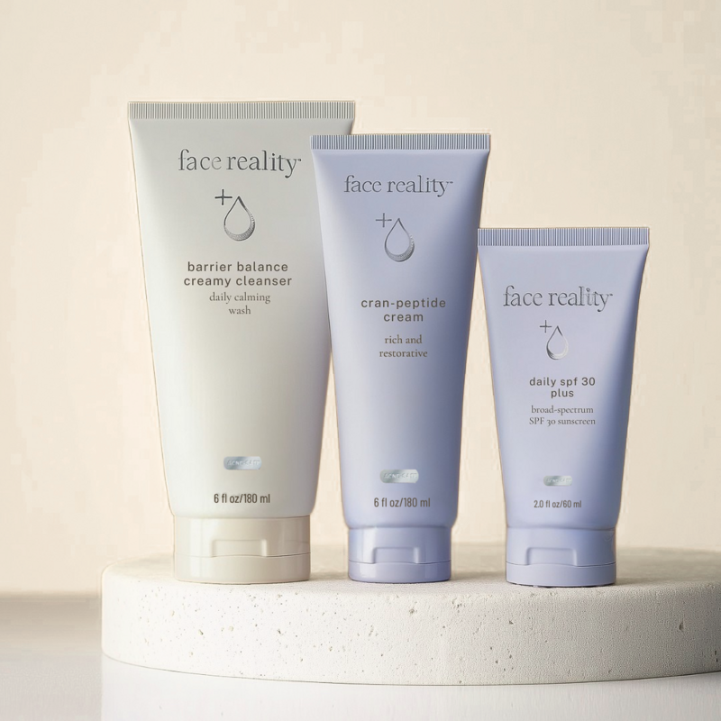 Flat lay of Face Reality skincare products on travertine stone surface.