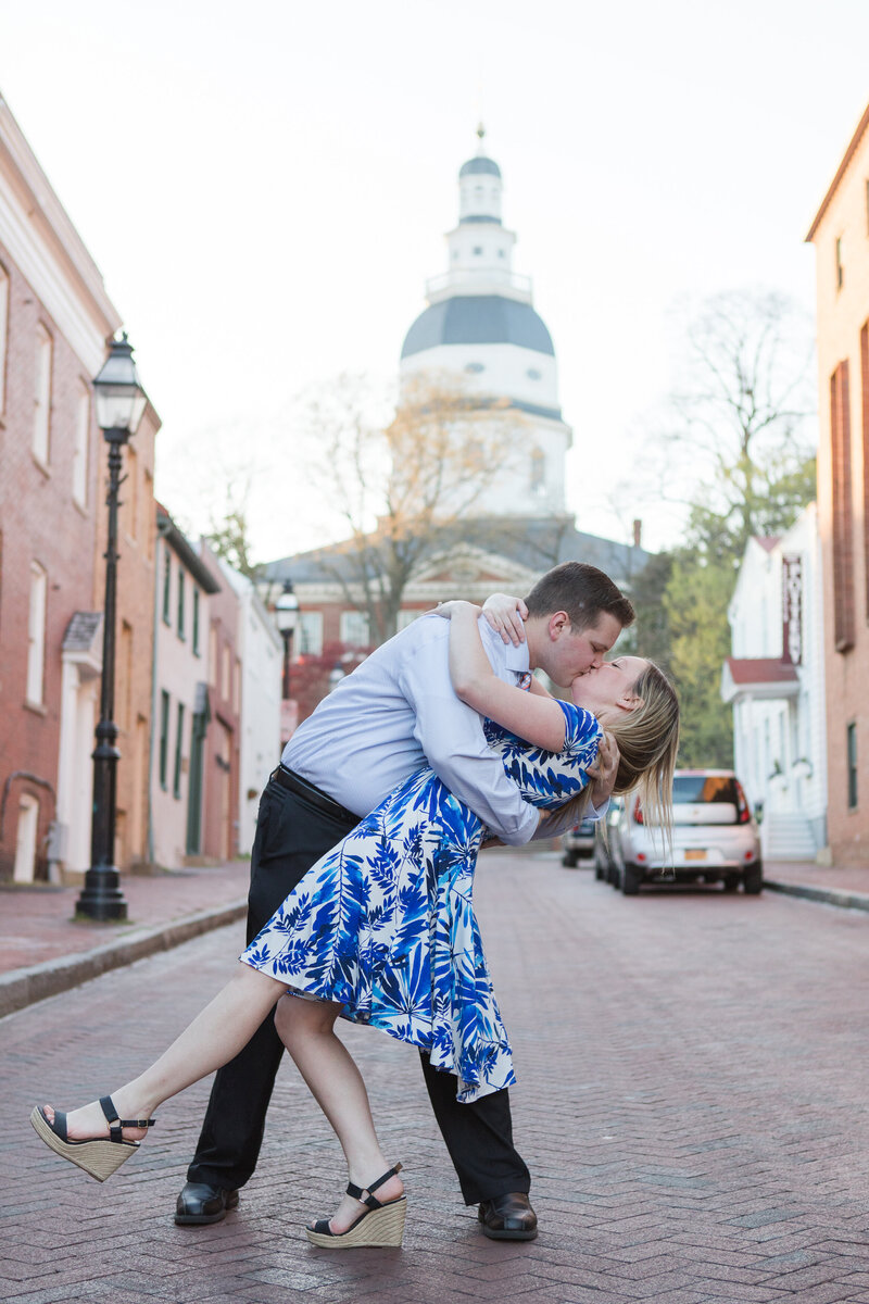 Downtown Annapolis engagement photo of couple dip kissing Maryland State House by Christa Rae Photography