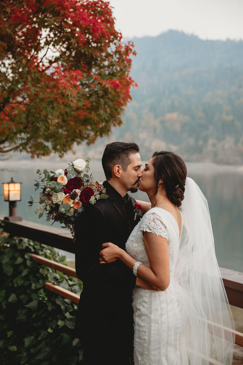 The first kiss at a fall lake side wedding