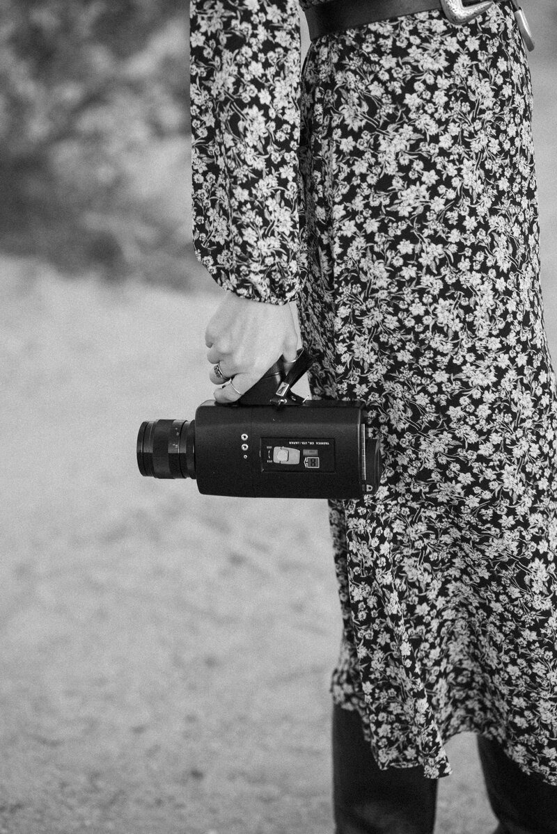 Close up of a woman's hand holding a super 8 film camera