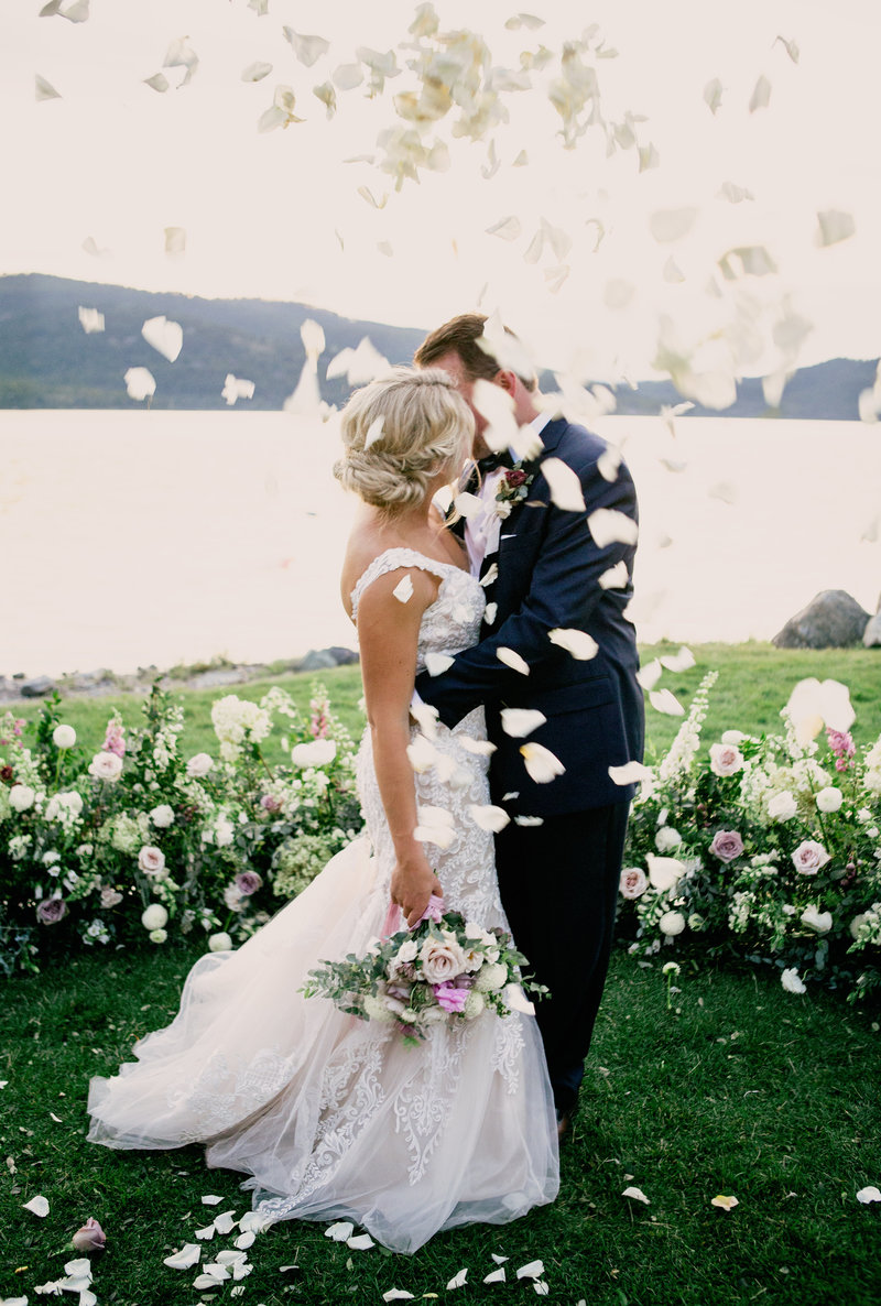 Destination Wedding in Whitefish Montana at the Lodge at Whitefish Lake Couple kissing with flower petals floating by Jennifer Mooney Weddings