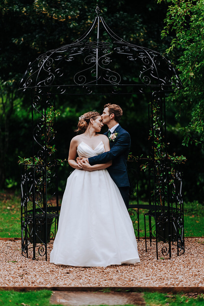 bride in white dress kissing groom