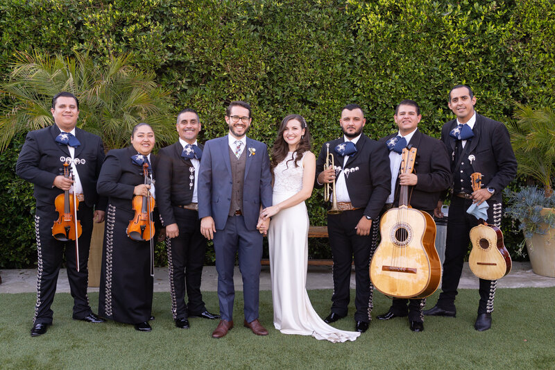 Bride and groom surrounded by mariachi band at their wedding reception