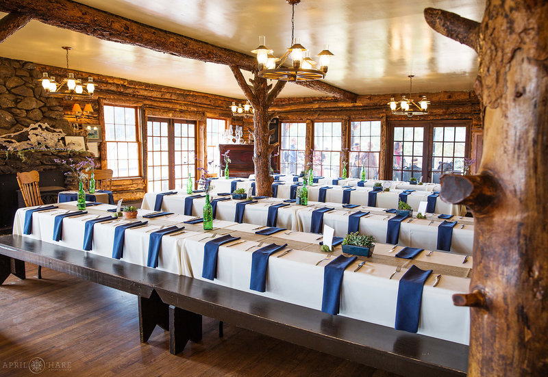 Long tables set up inside Colorado Mountain Ranch wedding reception summer camp in Boulder