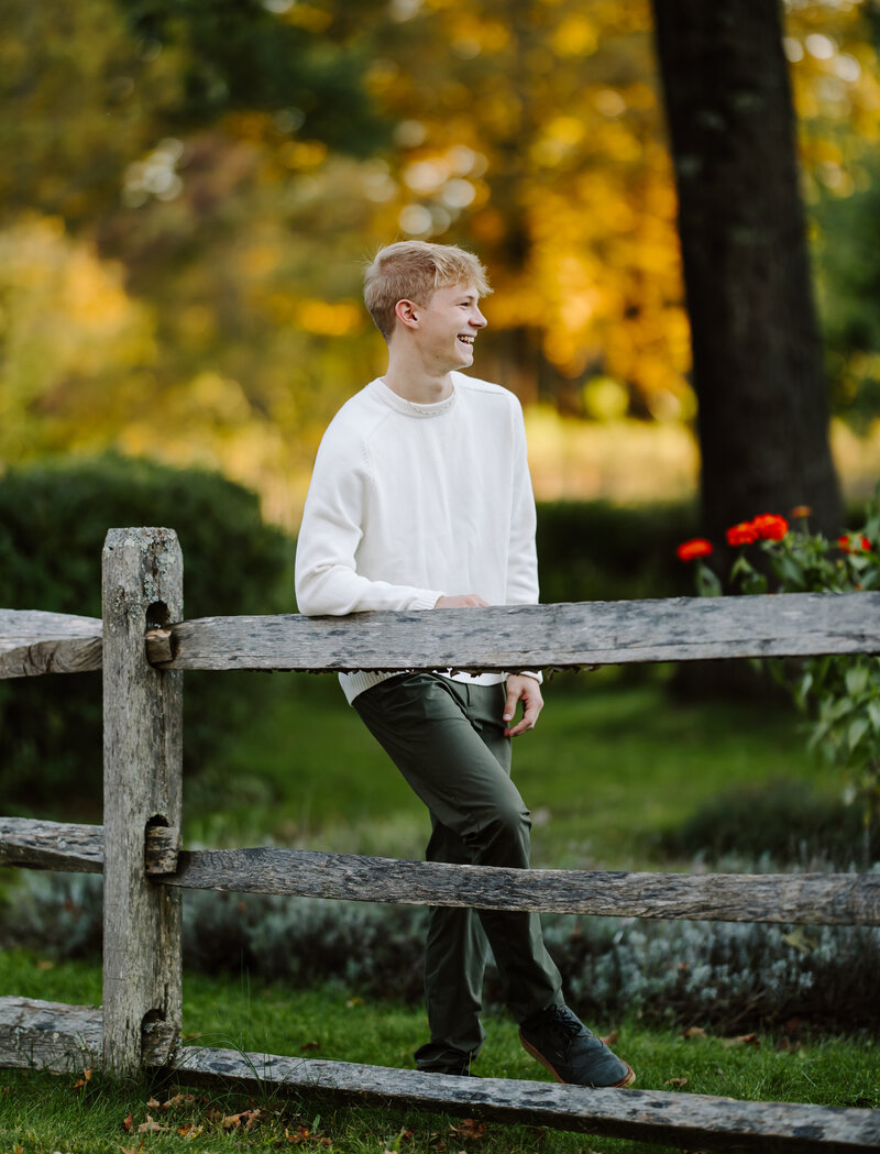 Senior boy smiles and looks away from camera at his senior session in Hollis, NH