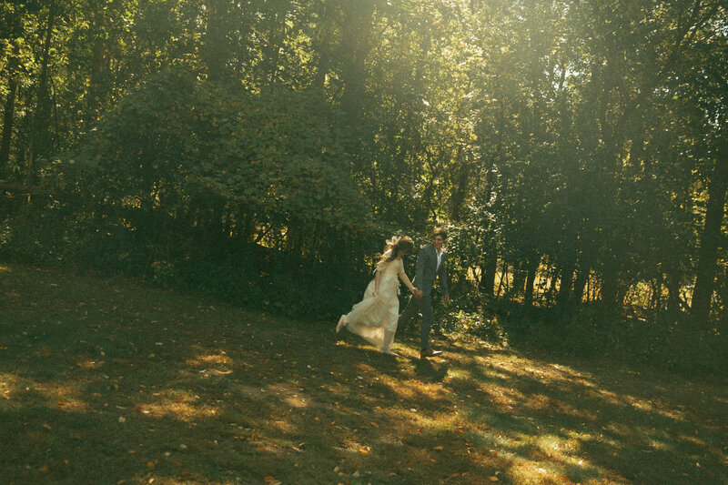 Man and woman romantically spin around, laughing in the middle of a  flowery field