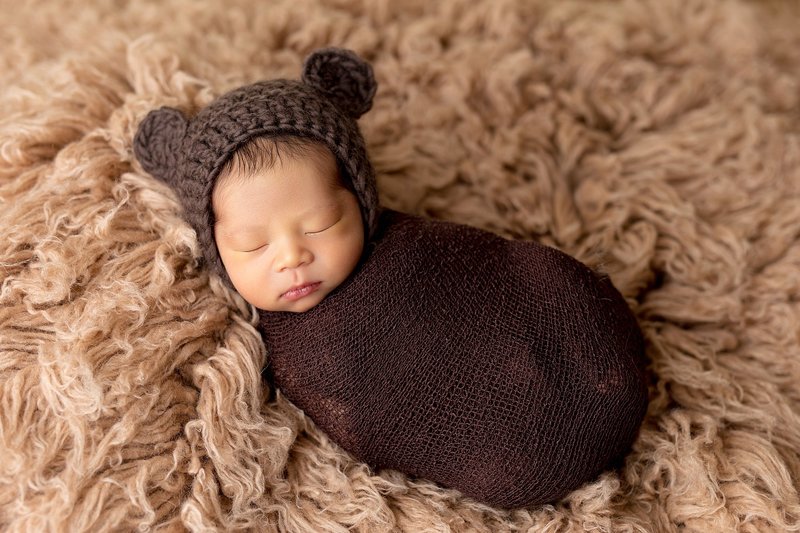 Newborn in dark brown bear outfit
