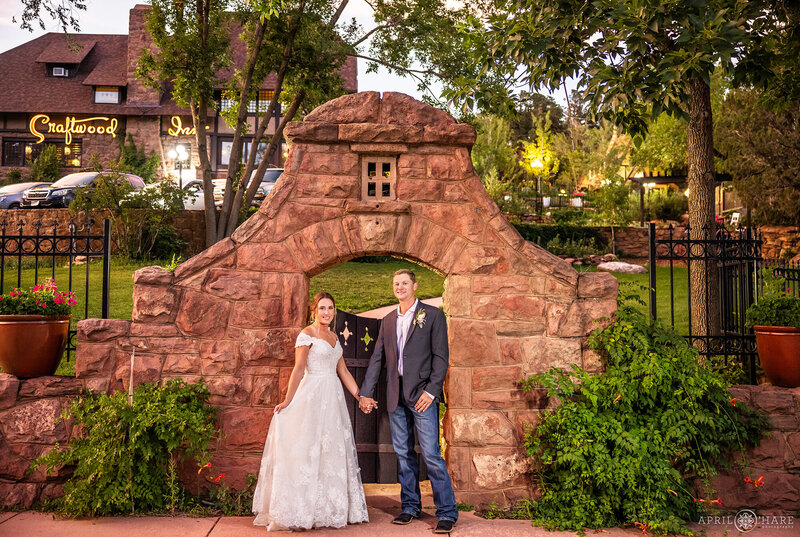 Couple Hold Hands at Sunset in front of the Red Sandstone Gate at Craftwood Peak Wedding Venue in Manitou Springs Colorado