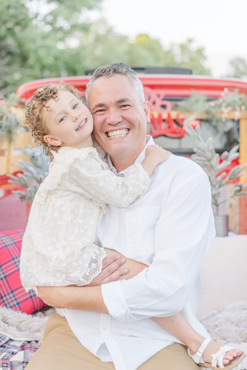 dad hugs daughter during red truck mini session in Northern Virginia