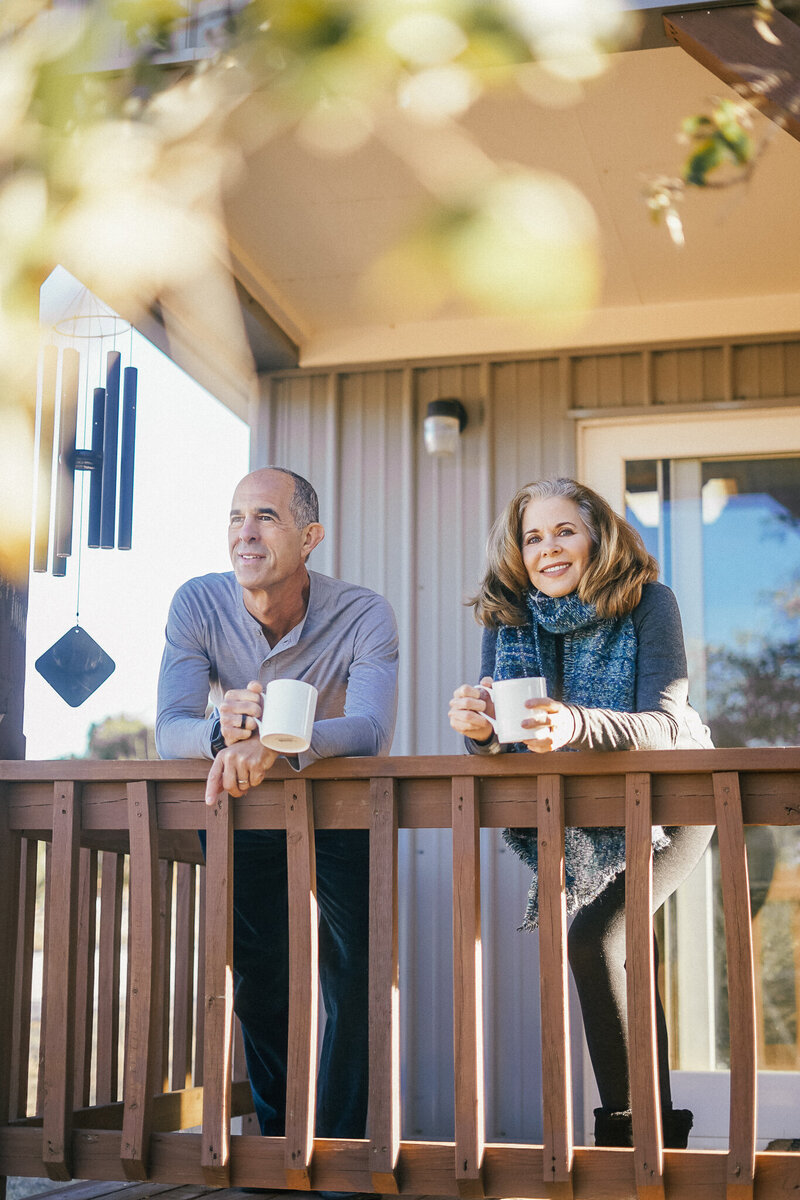 Man and woman drinking coffee outside on a porch