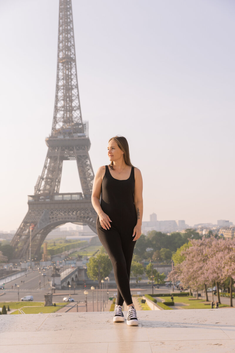 girl posing for photo in front of eiffel tower