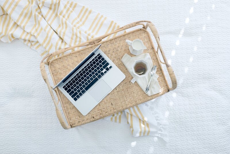 laptop on a wicker tray with tea