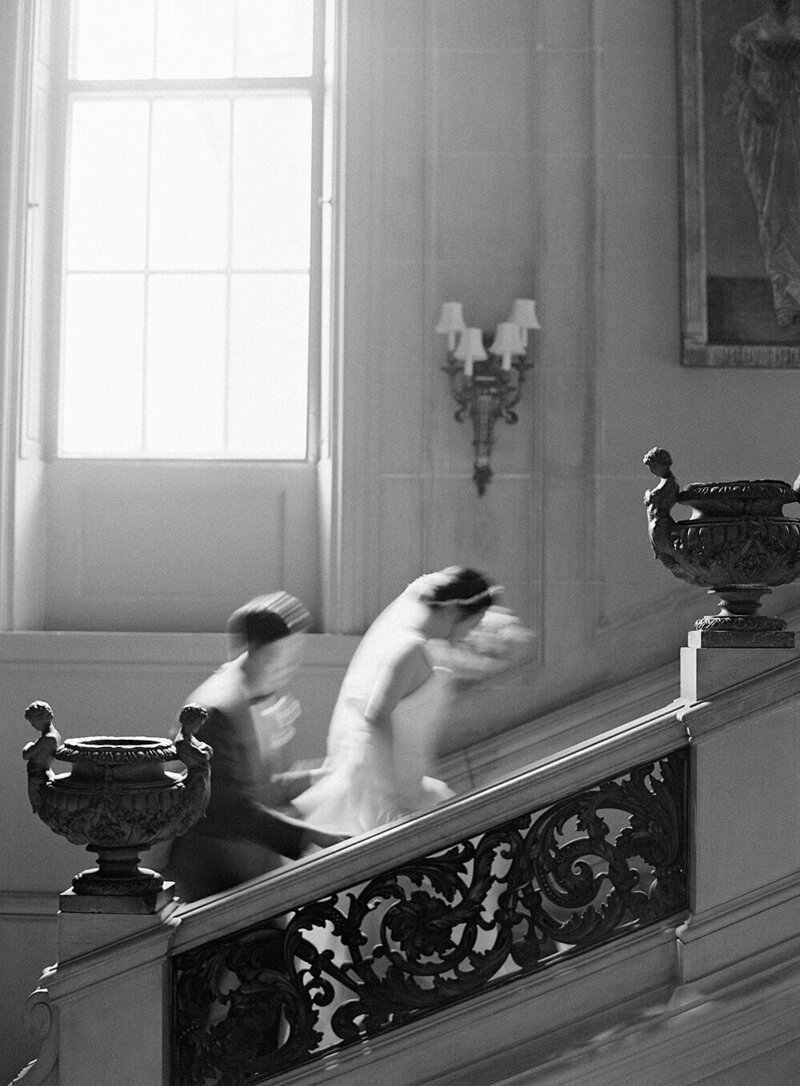 Bride and groom walk up stairs in a motion blur in black and white at Larz Anderson House - Washington DC with Seattle Wedding Photographer  Jacqueline Benét