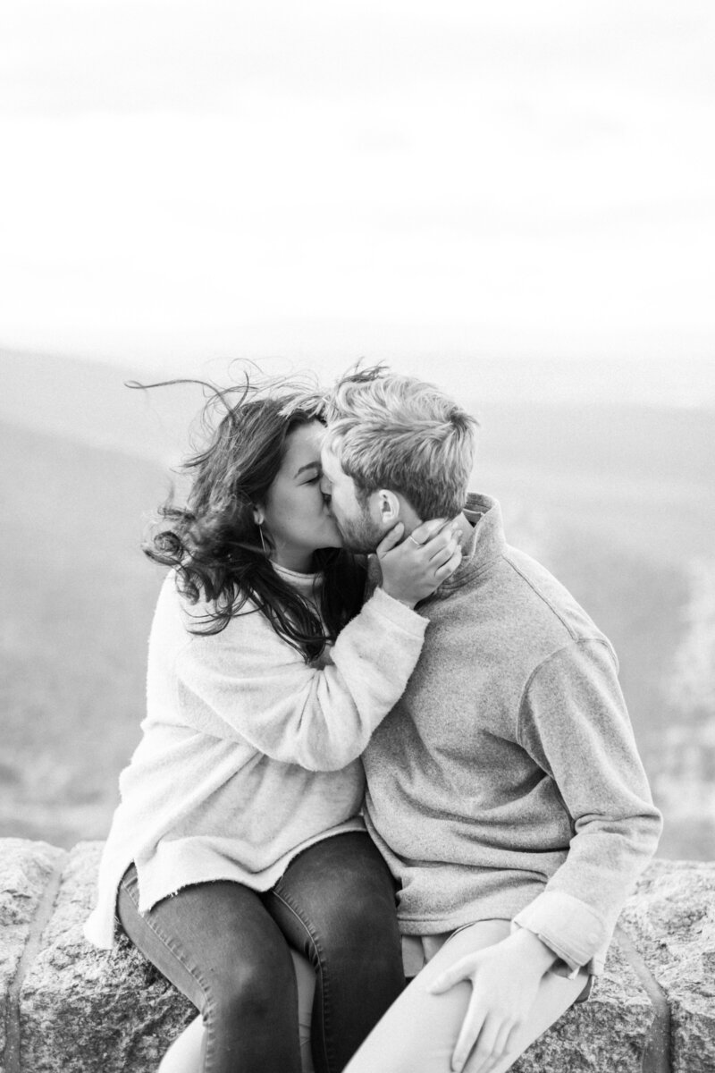 Engaged couple kisses at Ravens Roost Overlook near Charlottesville..