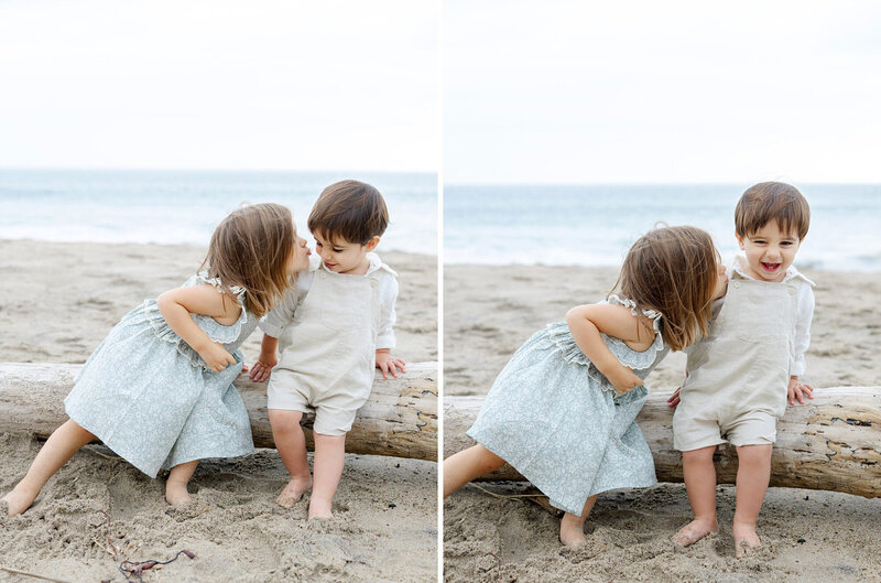 Two young child siblings sitting on a piece of driftwood during a beach child portrait session