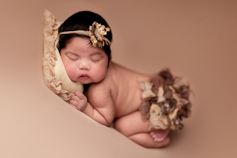 baby girl sleeping on a beige fabric